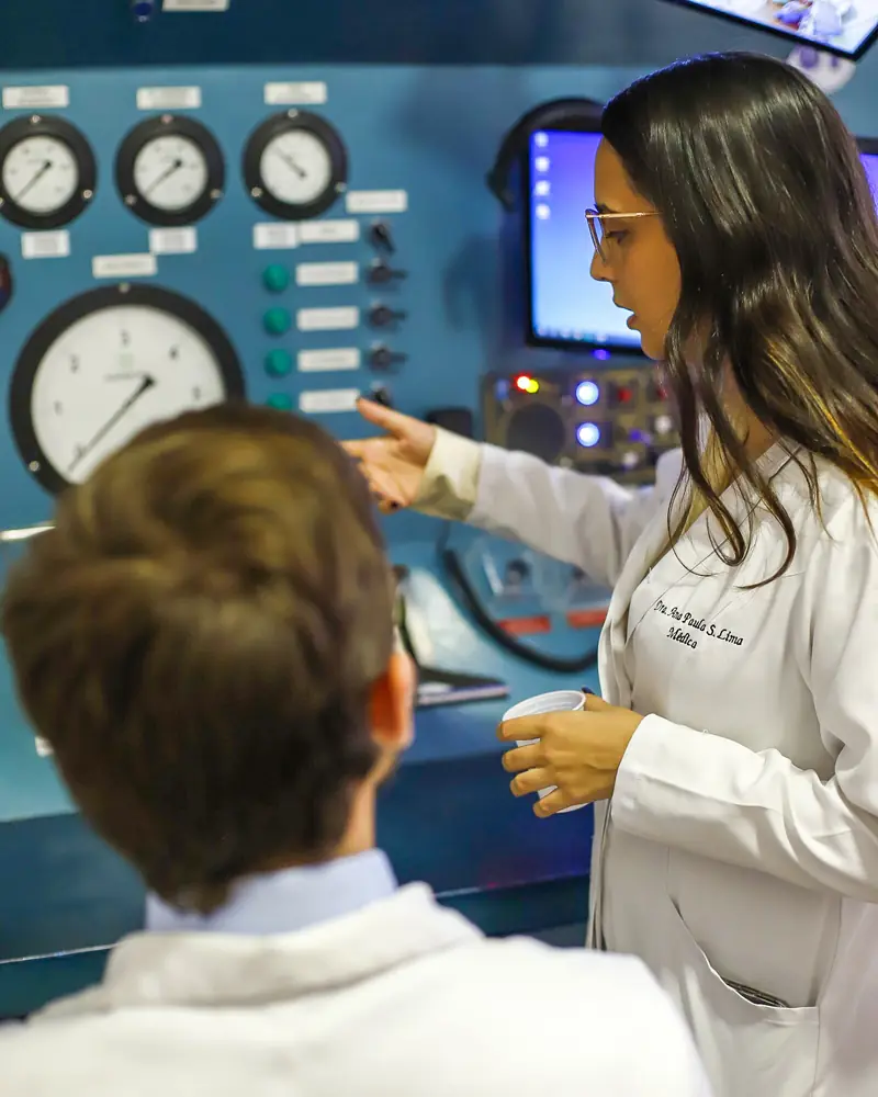 Médica e médico no painel de comando da câmara multiplace